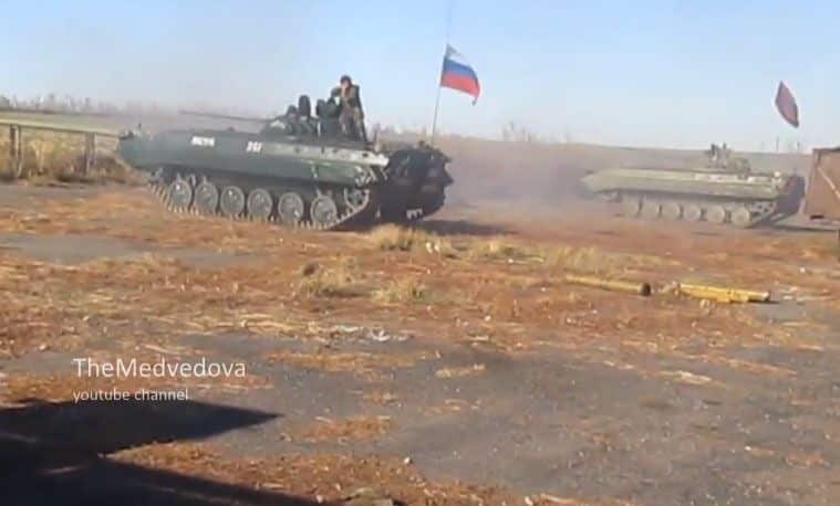 Russian terrorists firing Ukrainian troops from armored vehicle with Russian flag
