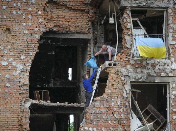Residents take out their belongings from their house ruined by the Russian shelling in Irpin close to Kyiv, Ukraine, Saturday, May 21, 2022. (AP Photo/Efrem Lukatsky)